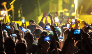 concertgoers with phones at outdoor concert